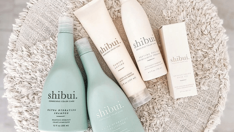 Shibui hair care products displayed on a textured surface, including shampoo, conditioner, and cream.