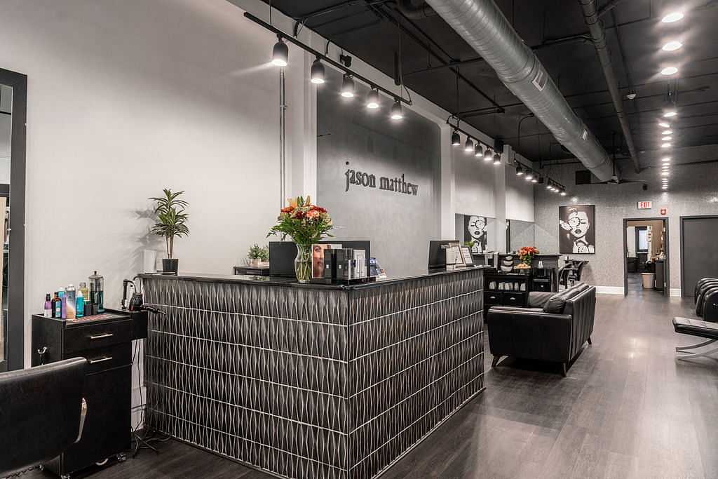 Modern hair salon with stylish decor, pendant lighting, and a welcoming reception desk.
