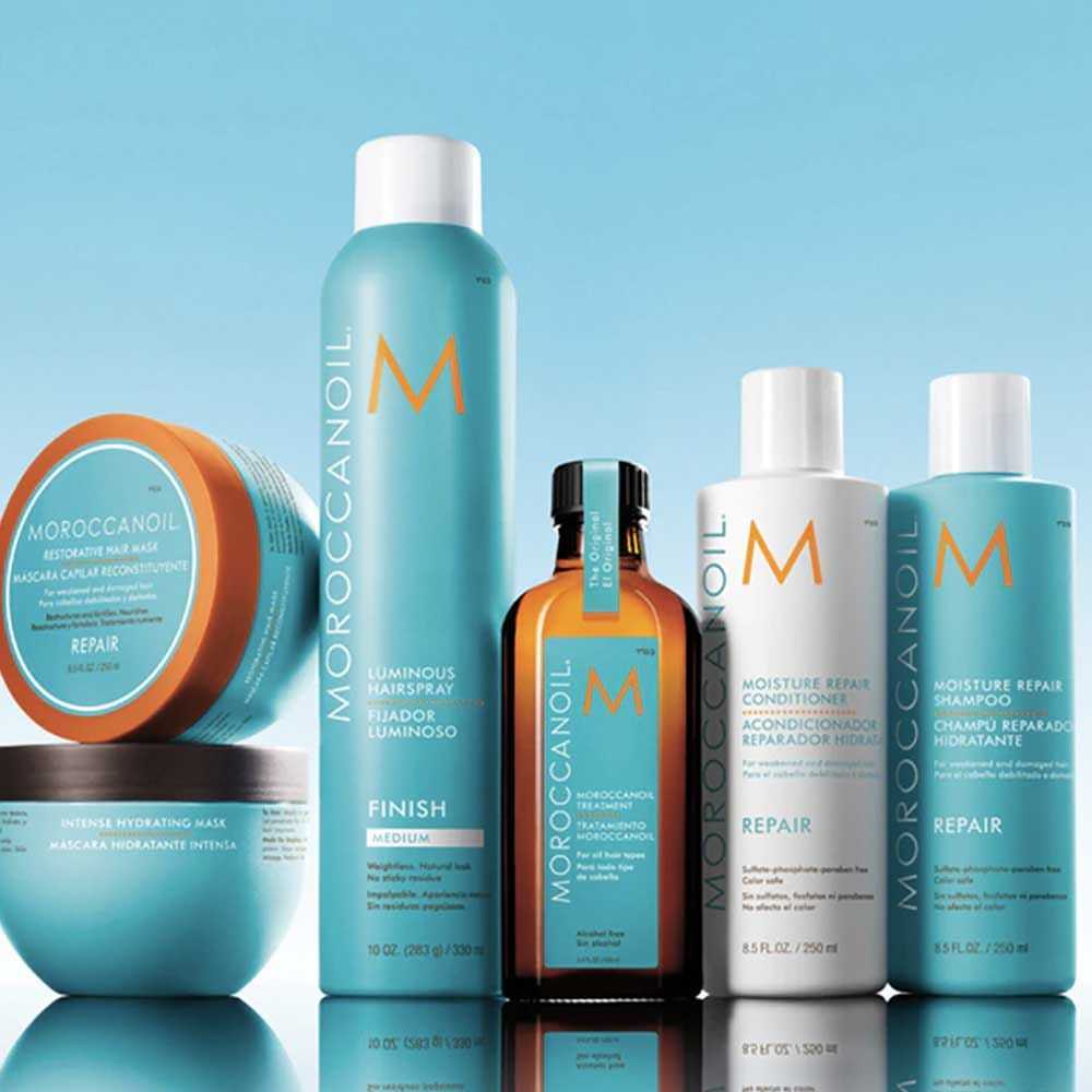 Haircare products including shampoo, conditioner, hair mask, and oil on a reflective surface.